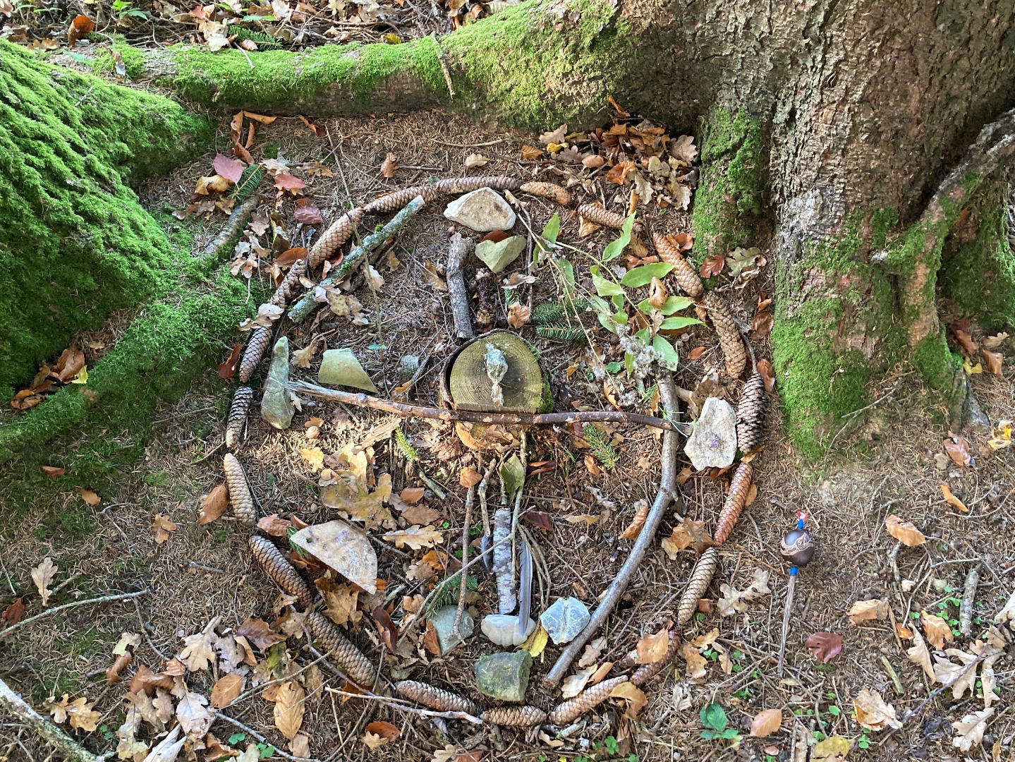 "Sandbild", gelegtes Bild am Waldboden aus Naturgegenständen